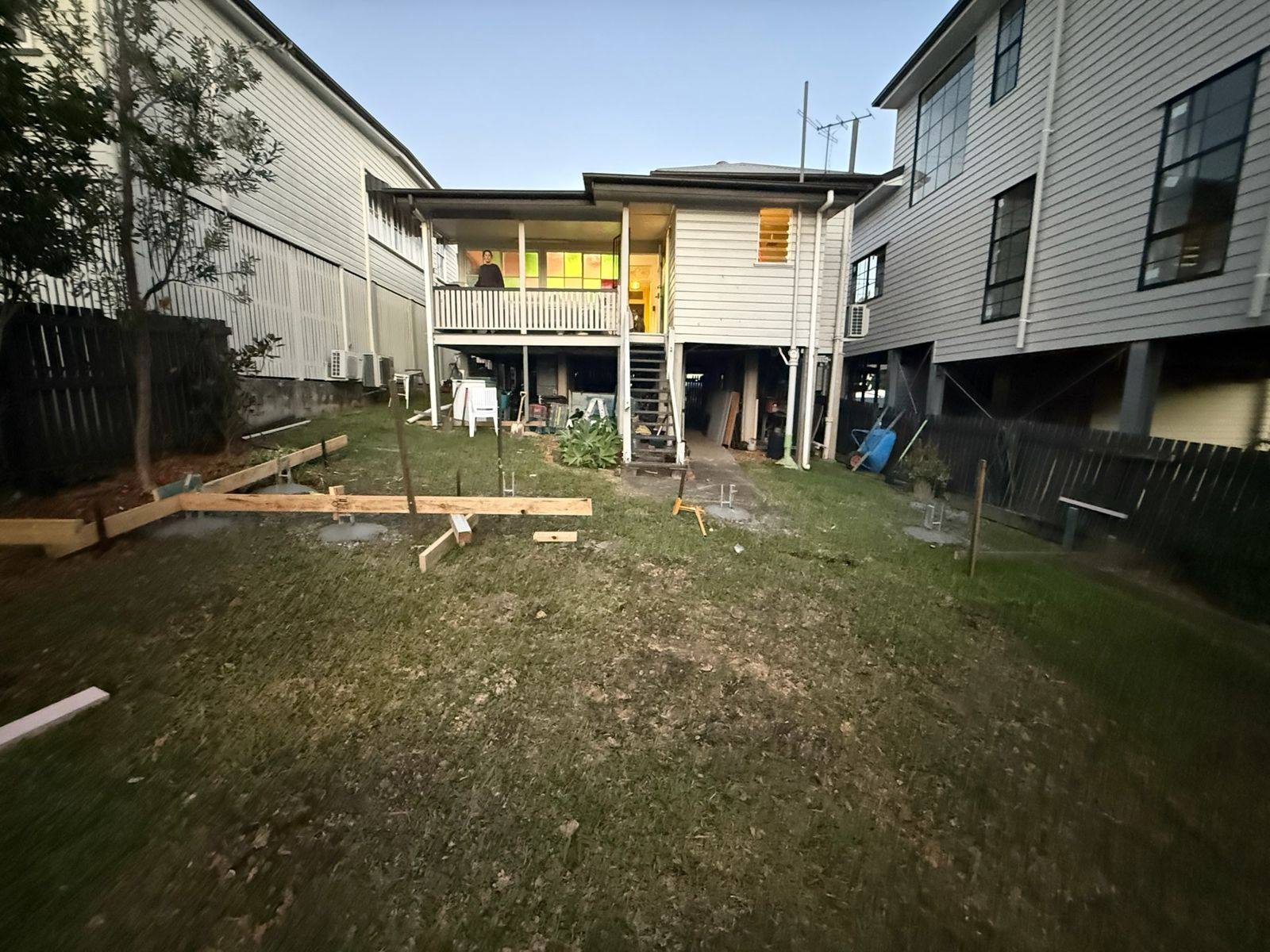 The back of a raised Queenslander before the extension, with new pier footings poured in the lawn