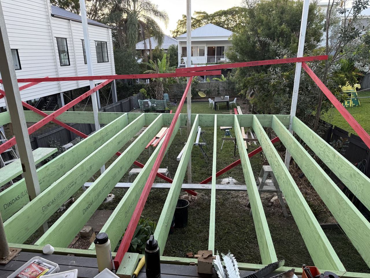 New LVL floor joists for the extension laid across the subfloor, with red temporary bracing above