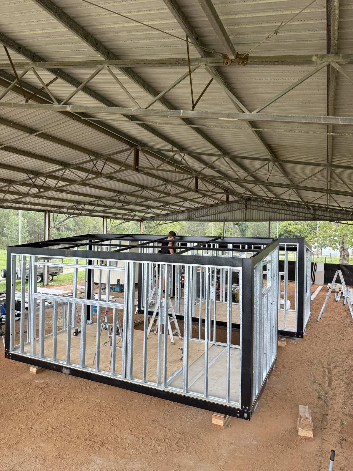 Steel wall and floor frames for two modular homes taking shape in the factory shed
